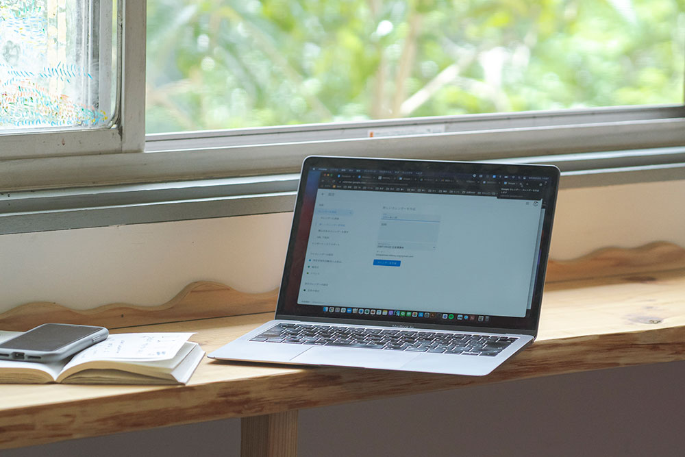 写真：窓際に広げた Macbook とノート
